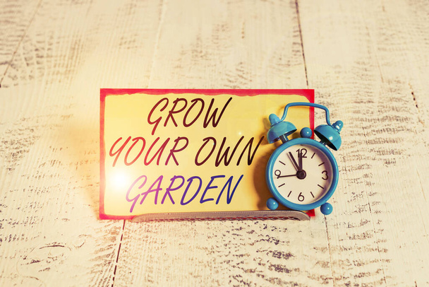自分の庭を育てるノートを書く。有機園芸を紹介するビジネス写真は、野菜の果物を実証する収集ノートペーパーの前でバッファ線の上に傾ける目覚まし時計. - 写真・画像