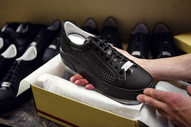 Rento mustat kengät tehtaalla
 - Valokuva, kuva