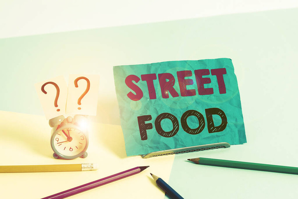 Word writing text Street Food. Business concept for cooked food sold by vendors in a street or other public location Mini size alarm clock beside stationary placed tilted on pastel backdrop. - Fotó, kép