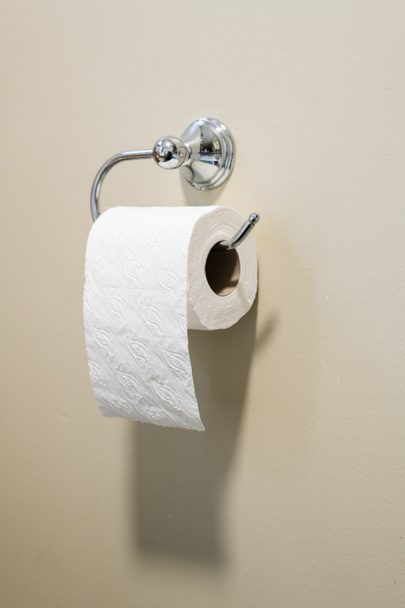 Du papier tissu accroché au mur des toilettes. Presque plein de roulis
. - Photo, image