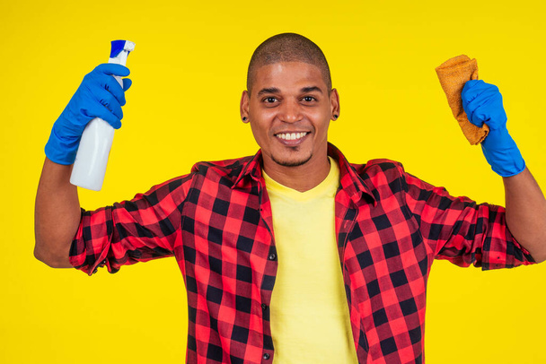 latin brazilian cleaning man wearing ribon gloves in studio yellow background - Fotografie, Obrázek