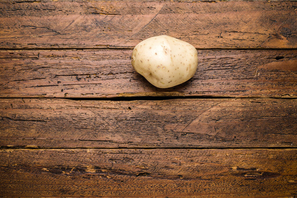Top pohled čerstvé organické brambory na dřevěné desce stolu - Fotografie, Obrázek