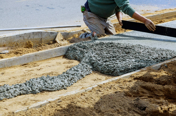 Trabajadores de la construcción colocando hormigonera con hormigonera en la acera
 - Foto, imagen