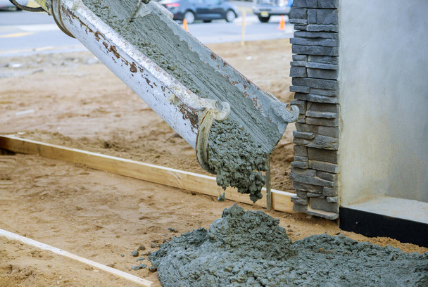 Camión de hormigón con cemento vertido durante el enfoque selectivo de la calle residencial
 - Foto, Imagen