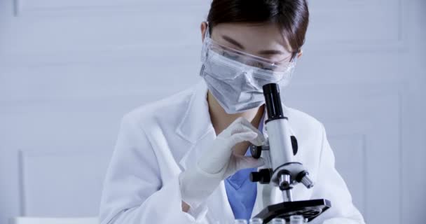 scientist in the laboratory working at lab with microscope - Video
