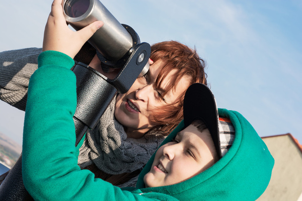 Молодий хлопчик з бабусею дивиться через телескоп
 - Фото, зображення