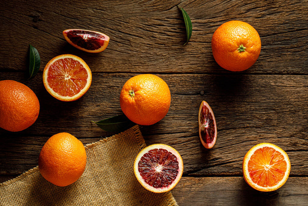 Sliced Sicilian Blood sinaasappels fruit over oude donkere houten achtergrond. Bovenaanzicht. - Foto, afbeelding