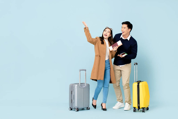 Hermosa pareja asiática turistas con pasaportes de equipaje y tarjetas de embarque a punto de ir de viaje de luna de miel
 - Foto, Imagen