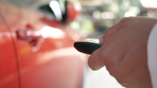 Close-up of Woman's hand open the car with car remote key at home. Car auto alarm and remote central lock concept. - Video