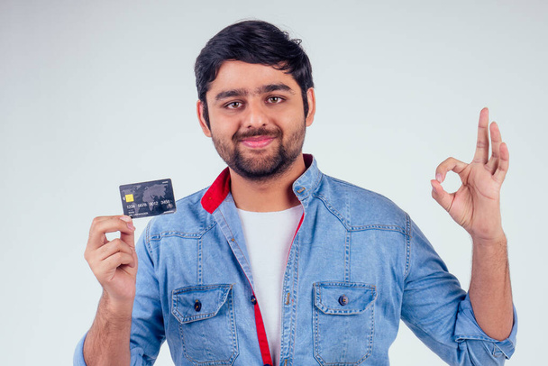 happy indian male holding credit card in studio white background - Фото, зображення