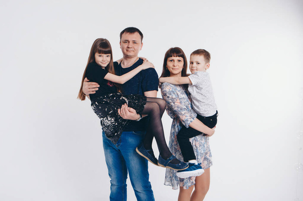 the concept of a healthy lifestyle, the protection of children, shopping - baby in the arms of the mother and father on white background. Woman and man holding a child. Copy space - Foto, immagini