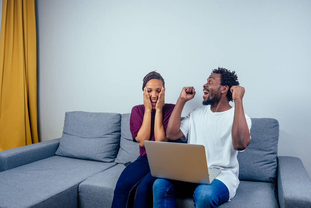Portrait of an happy couple using a laptop computer in their house. - Foto, Imagem