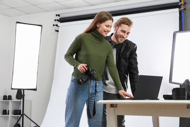 Professional photographer showing pictures to model in studio - Foto, immagini