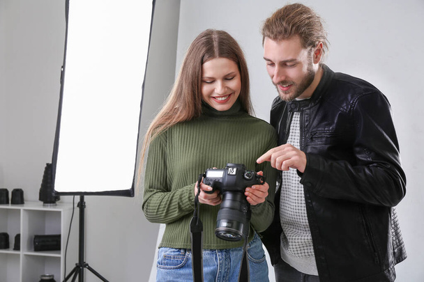 Professional photographer showing pictures to model in studio - Φωτογραφία, εικόνα
