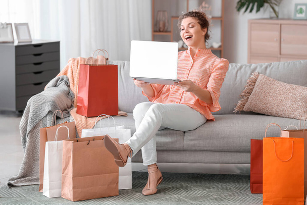 Piękna młoda kobieta za pomocą laptopa do zakupów online w domu - Zdjęcie, obraz