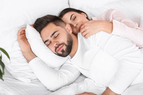 mladý pár spí v posteli doma - Fotografie, Obrázek