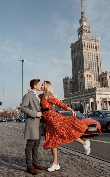 若いカップルがヨーロッパの都市を旅しました。ワルシャワのラブストーリー。少女と一緒に街の通りを歩く男 - 写真・画像