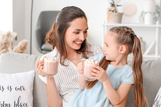 Woman and her little daughter drinking tasty cocoa at home - Photo, Image