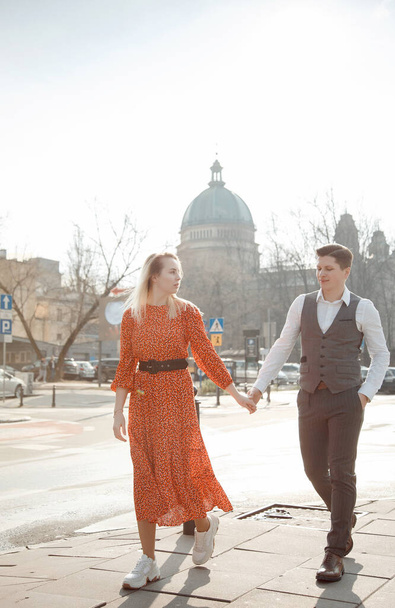 een jong stel dat door Europese steden reist. Liefdesverhaal in Warschau. De man met het meisje loopt door de straten van de stad. - Foto, afbeelding