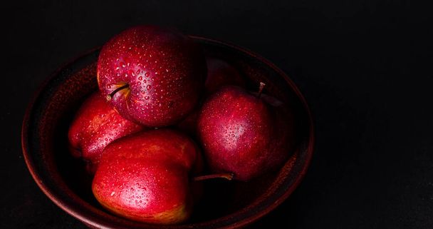 Verse sappige rode appel met druppels water tegen donkere achtergrond met ruimte voor tekst - Foto, afbeelding