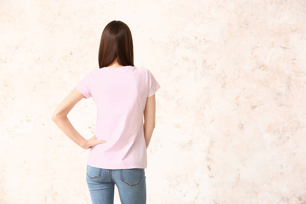 Nainen tyylikkäässä t-paidassa valoisalla taustalla
 - Valokuva, kuva