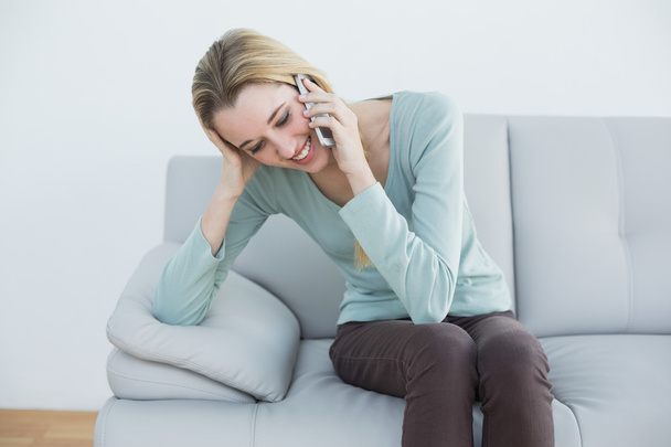 Lovely casual woman phoning while sitting on couch - Zdjęcie, obraz