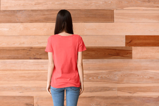 Kobieta w stylowej koszulce na drewnianym tle - Zdjęcie, obraz