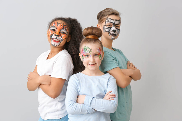 Zabawne dzieci z malowaniem twarzy na jasnym tle - Zdjęcie, obraz