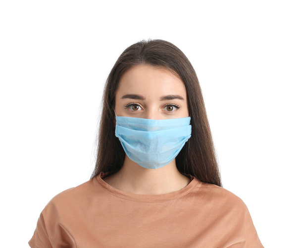 Νεαρή γυναίκα που φοράει ιατρική μάσκα σε λευκό φόντο - Φωτογραφία, εικόνα