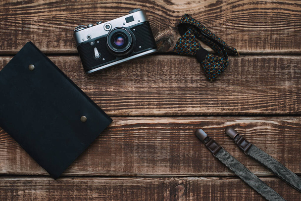 father's day with men's accessories bow tie, wallet, retro camera, suspenders and notepad and leather shoes on a wooden background. Copy space. Flat lay. - Foto, imagen