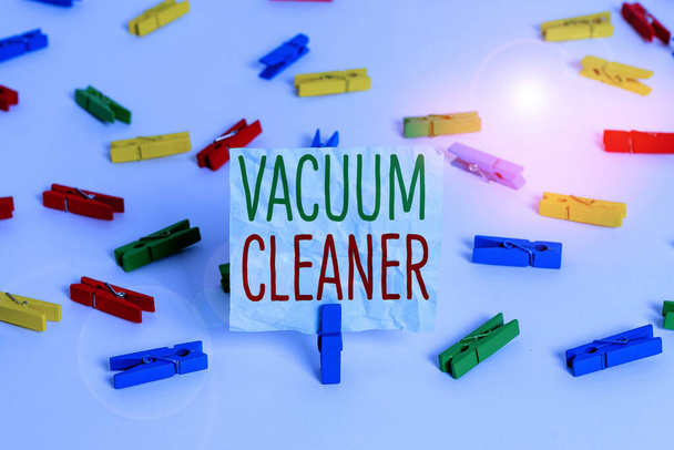 Handwriting text Vacuum Cleaner. Concept meaning machine that cleans floors and surfaces by sucking up dust Colored clothespin papers empty reminder white floor background office. - Photo, Image