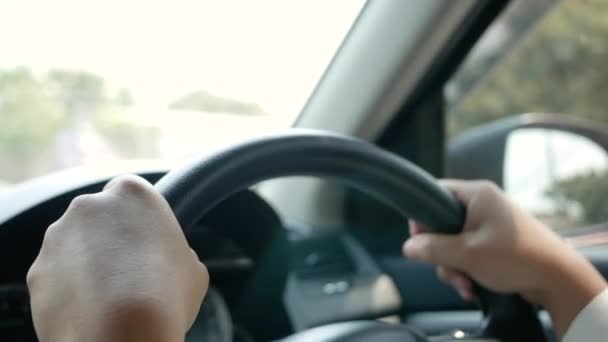 Νεαρή γυναίκα οδηγεί ένα αυτοκίνητο, το χέρι που τίθεται στο μαύρο τιμόνι και ανυπομονούμε να οδηγήσετε με προσοχή. - Πλάνα, βίντεο
