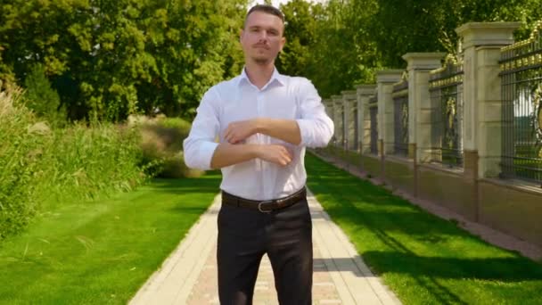 Een zakenman vouwt zijn armen over zijn borst en draait naar de camera - Video