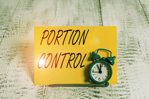 Writing note showing Portion Control. Business photo showcasing knowing the correct measures or serving sizes as per calorie Alarm clock tilted above buffer wire in front of notepaper. - Photo, Image