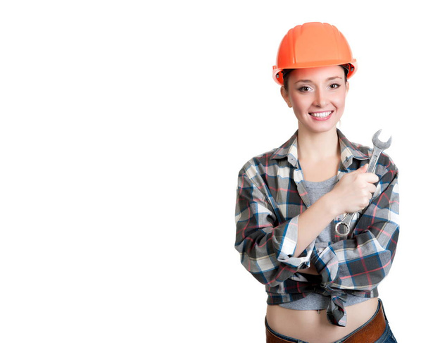 Beautiful girl in a building helmet holding a wrench - Foto, Imagem
