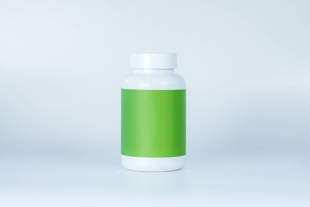 A bottle of supplements with green label - Fotoğraf, Görsel