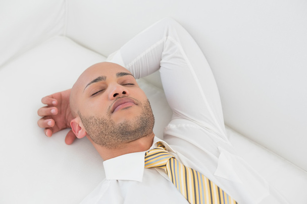 Businessman sleeping on sofa at home - Фото, зображення