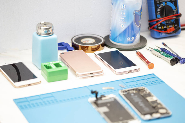 Hizmetteki cep telefonu parçalarının masası - Fotoğraf, Görsel