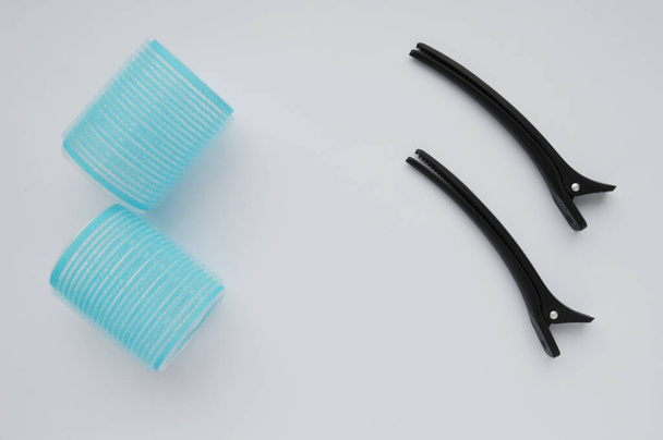 Zestaw niebieskie lokówki i czarne spinki do włosów izolowane na białym tle. - Zdjęcie, obraz