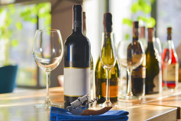 Conjunto de botellas y vasos de vino blanco, rosa y tinto. Servido en una mesa de madera con fondo borroso restaurante
. - Foto, imagen