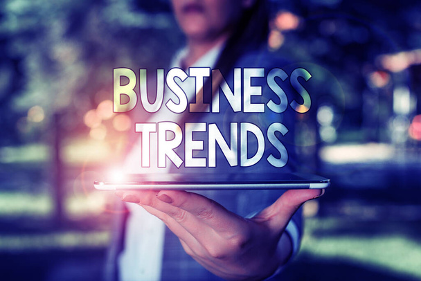 Conceptual hand writing showing Business Trends. Business photo text a general change in the way business is developing Outdoor scene with business woman holds lap top with touch screen. - Photo, Image