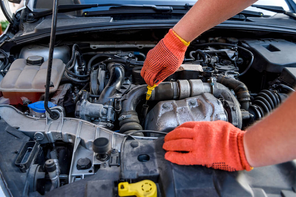 Hands of mechanic's in protective gloves with car engine close up - Photo, image