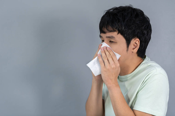 sick young man is sneezing - Fotoğraf, Görsel
