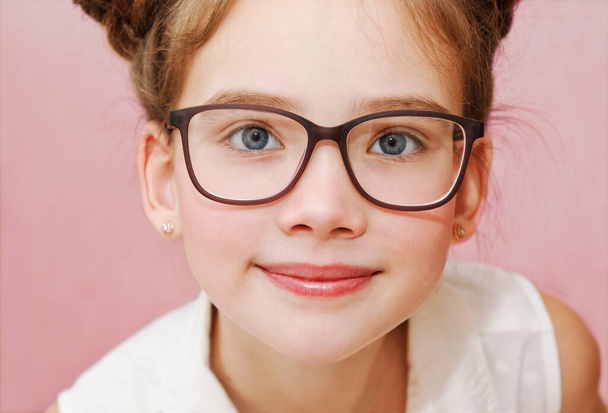 Cute little girl child preteen in eyeglasses education, school and vision concept isolated on a pink closeup - Fotoğraf, Görsel