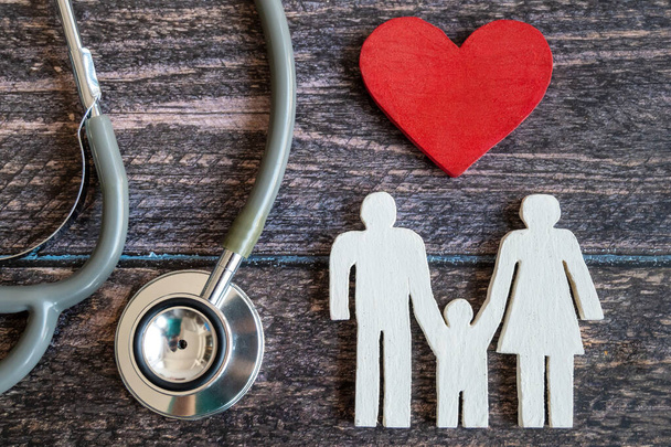 Красное сердце, стетоскоп и икона семьи на деревянном столе. Концепция медицинского страхования
 - Фото, изображение