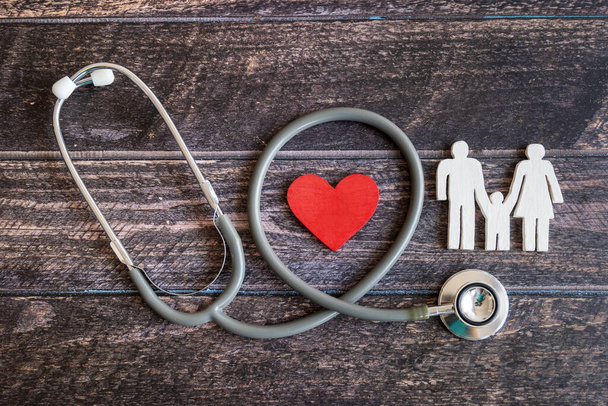 Red heart, stethoscope and icon family on wooden desk. Medical Insurance Concept - Фото, изображение