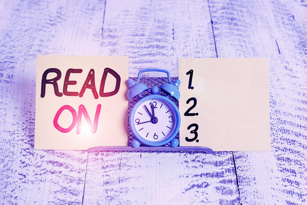 A felirat az Read On-t mutatja. Fogalmi fotó időt tölteni olvasás annak érdekében, hogy megtudja információkat valamit Mini kék ébresztőóra felett áll puffer huzal között két jelölőlap. - Fotó, kép