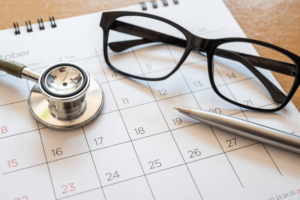 stethoscope and calendar on wooden table, schedule to check up healthy concept - Photo, Image