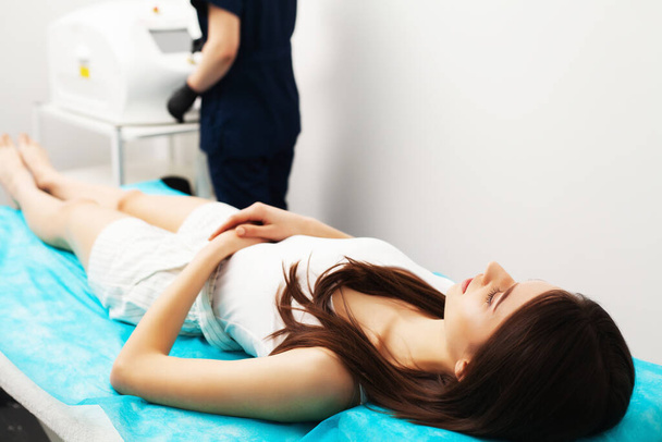 Pretty woman receiving laser hair removal service in beauty salon - Photo, Image
