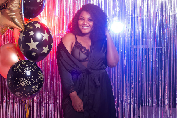 Ritratto di una bella donna afroamericana sullo sfondo scintillante. Festa di compleanno, discoteca e concetto di vita notturna
. - Foto, immagini